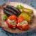 front-view-eggplant-dolma-with-cooked-tomatoes-bell-peppers-filled-with-ground-meat-inside-plate-blue-background