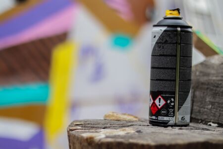 A graffiti can with artwork in the background