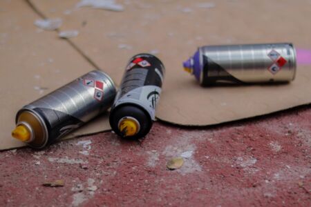 Three graffiti cans lying on the floor